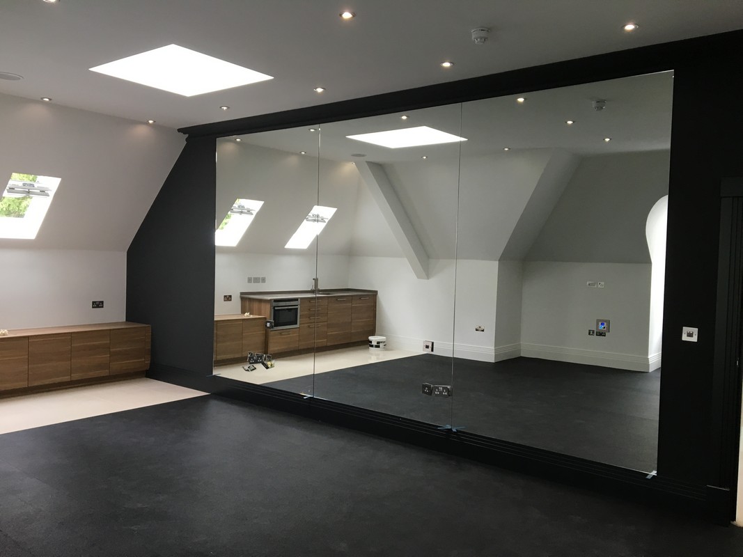 Frameless glass wall dividing loft conversion in Witney